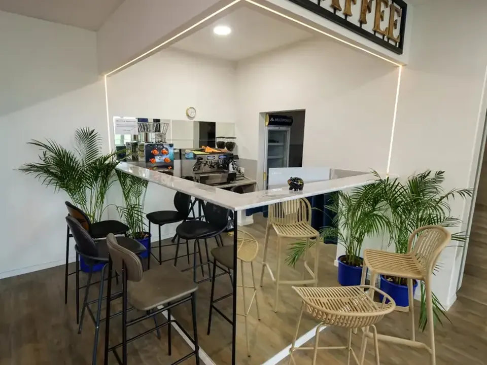 Kaffeebar mit Barhockern und Pflanzen
